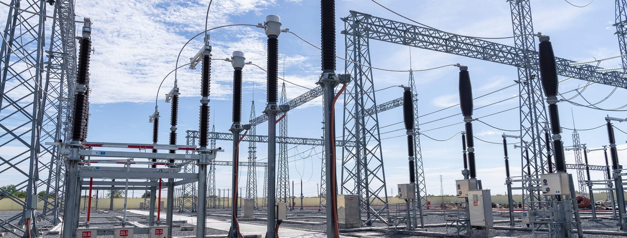 High-voltage switchyard with transmission gantries